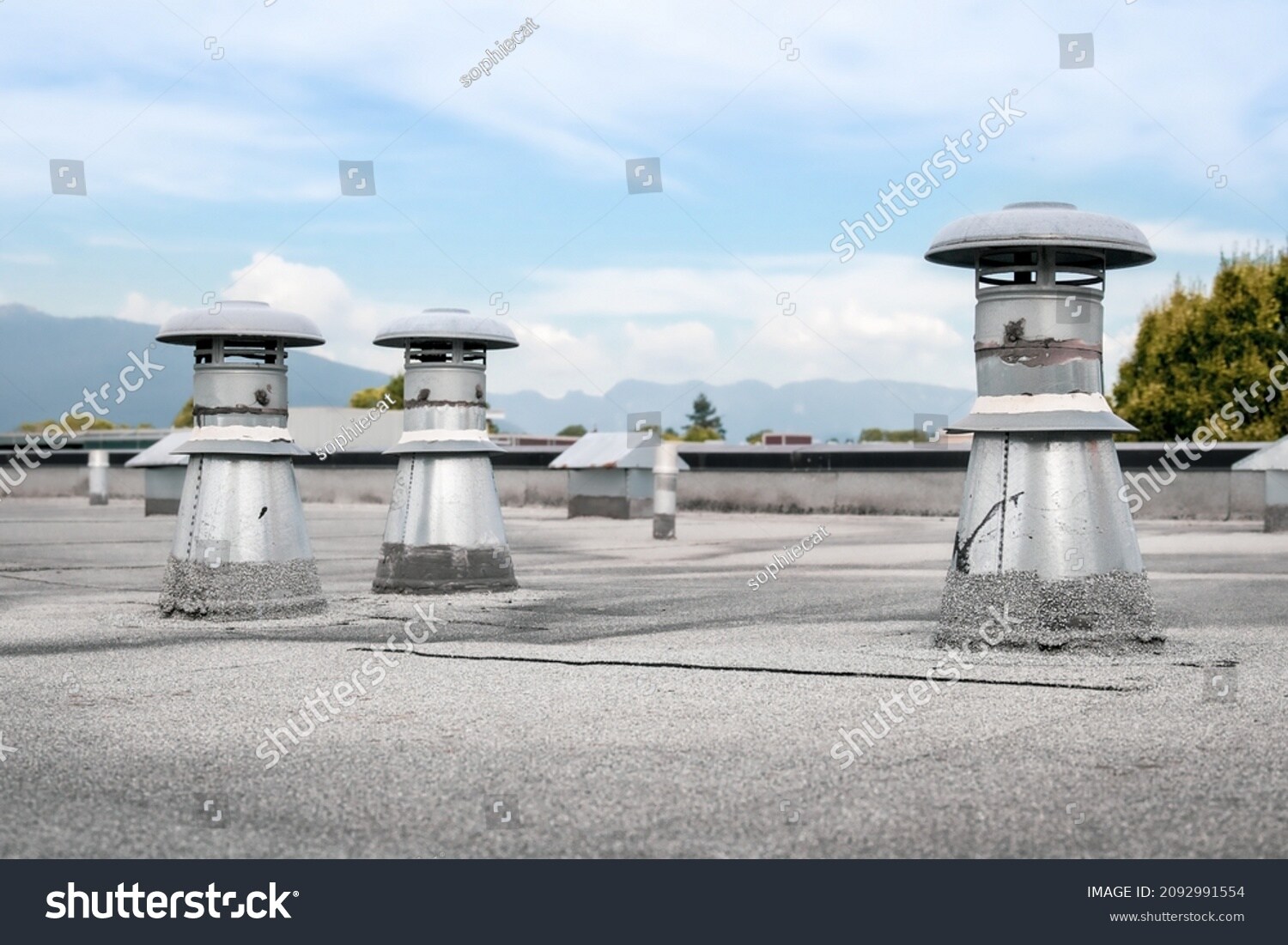 Flat roof vents on building with two-ply SBS roofing system.