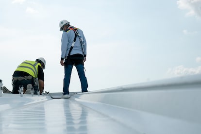 Two engineers inspect complex industrial roof.