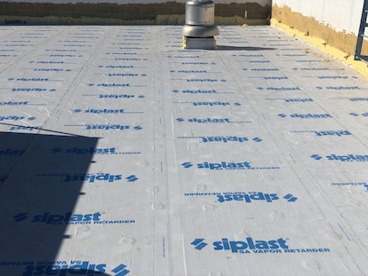 Worker applying sealant to vapor barrier.