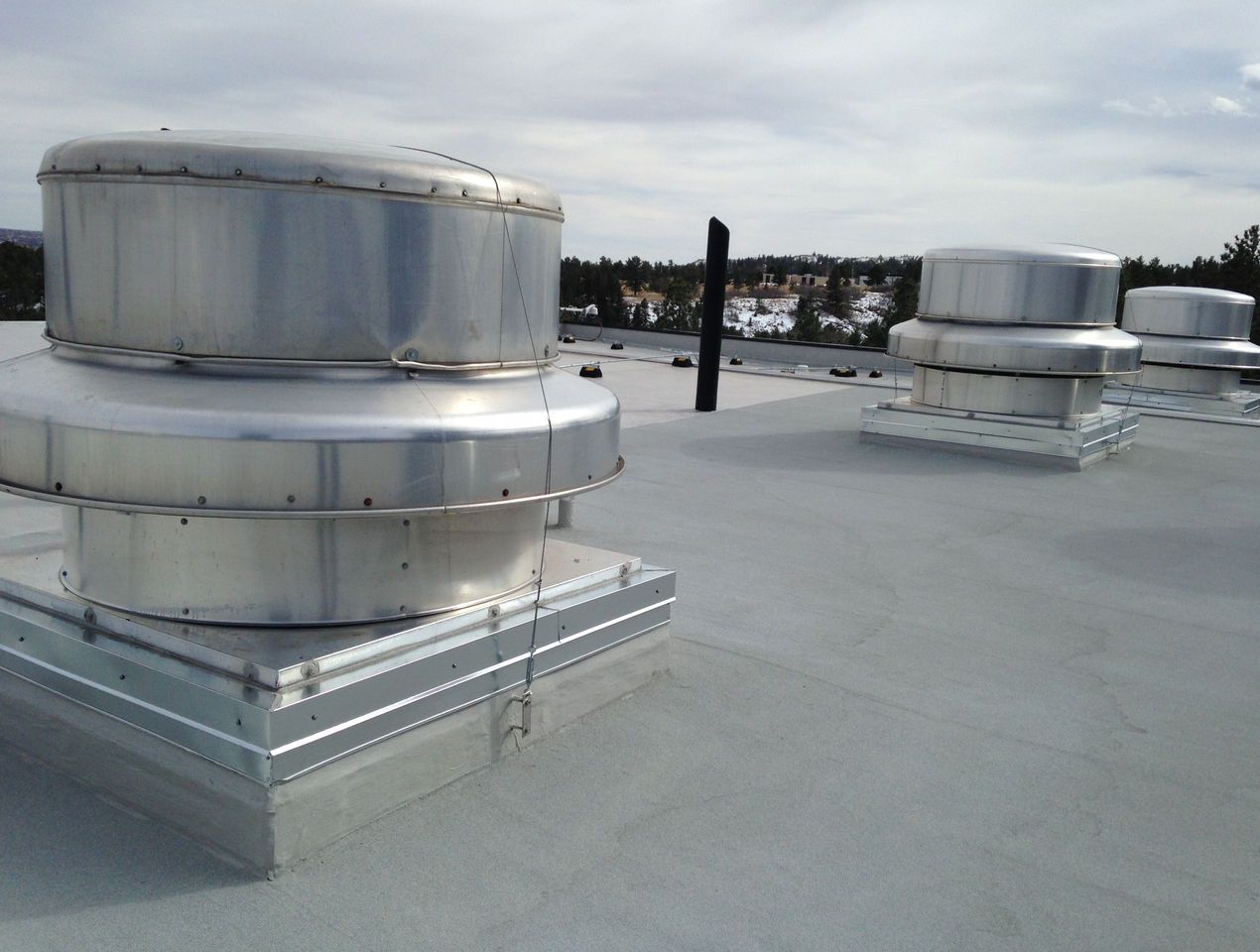 A commercial flat rooftop utilizing Siplast PMMA to create a liquid-applied membrane flashing designed to create a continuous seal.