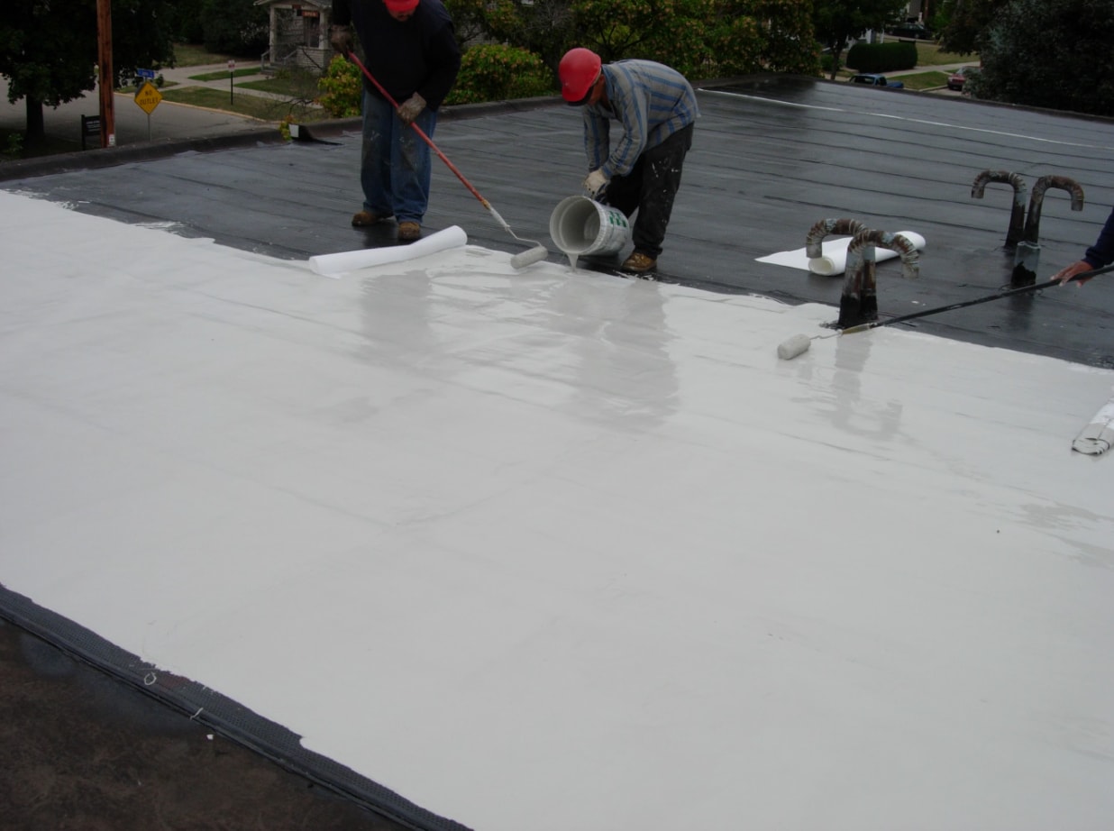siplast pmma contractors pouring roof membrane Two Siplast PMMA seasoned contractors pouring and rolling pmma roof membrane on a roof