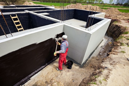 A contractor applies below-grade waterproofing.